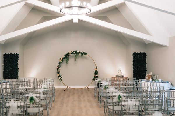 Ella's Garden decor - gold circle wedding backdrop with greenery, indoor ceremony location