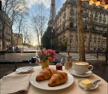 Parisian breakfast with croissants, coffee, and Eiffel Tower view.