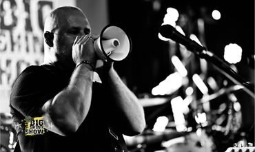 Man passionately speaking into a megaphone during a live performance.