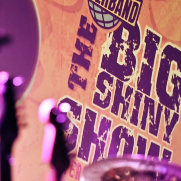 A colorful stage backdrop with "The Big Skinny Show" text partially visible.