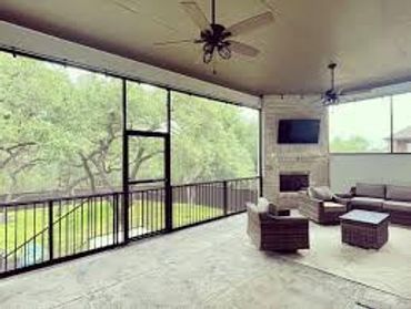Spacious screened-in porch with comfortable seating and ceiling fans.