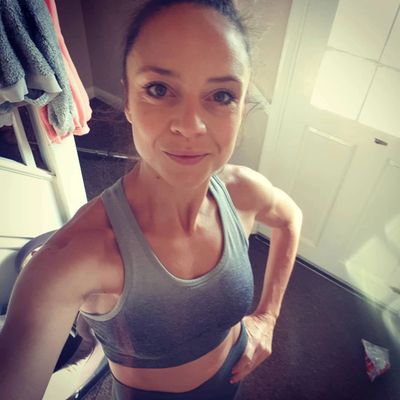 Leicester yoga and mindfulness coach in her gym wear looking happy.