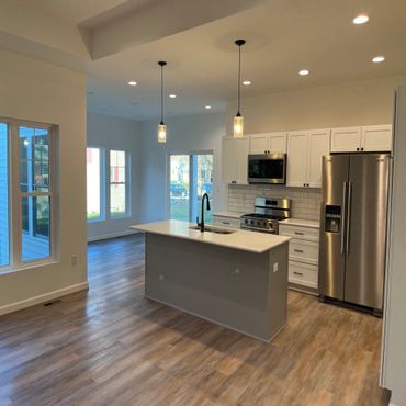 Modern kitchen with island, stainless steel appliances, and wood flooring.