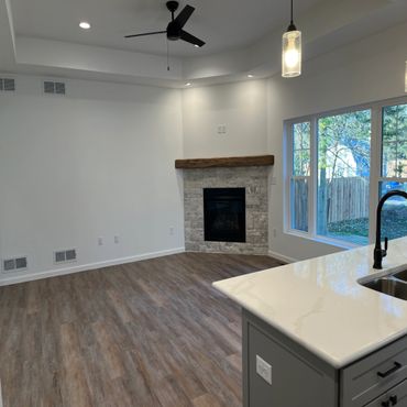 Modern living space with fireplace and kitchen island.