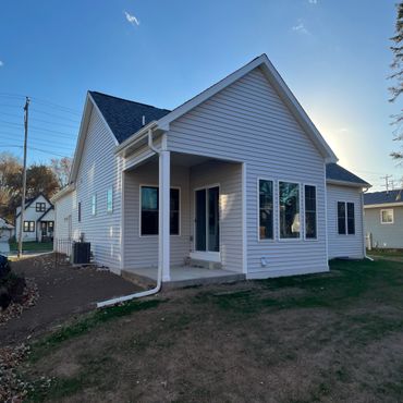 Newly built white house with a small porch and large windows.