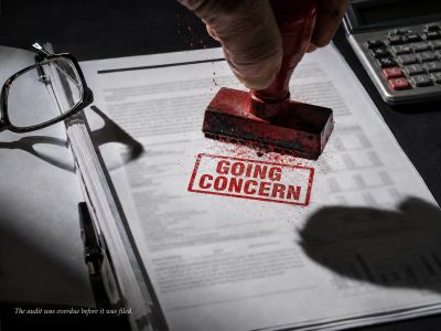 Red stamp hits document, ink splatters: GOING CONCERN stamped.