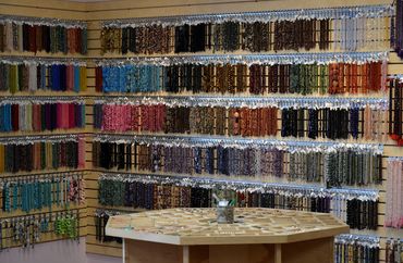 A portion of our stone bead wall showing many strands of  both shiny stone and matte stone beads