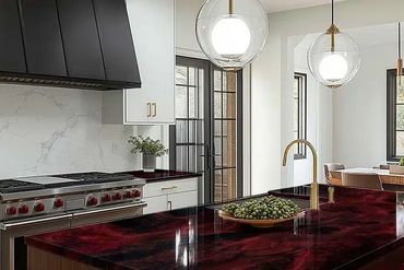 Modern kitchen with dark red marble countertops and white cabinets.