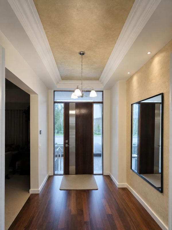 Elegant hallway with wooden door and large mirror.