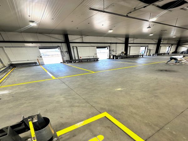 Large empty warehouse space with yellow floor markings.