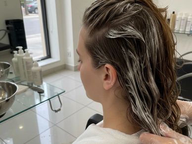 Person getting hair treatment at a salon.