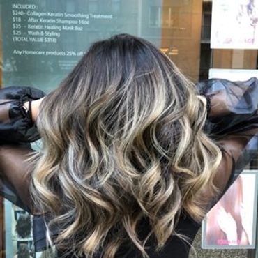 Long wavy hair with blonde highlights.