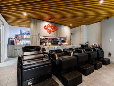 Modern salon washing stations with black leather chairs.