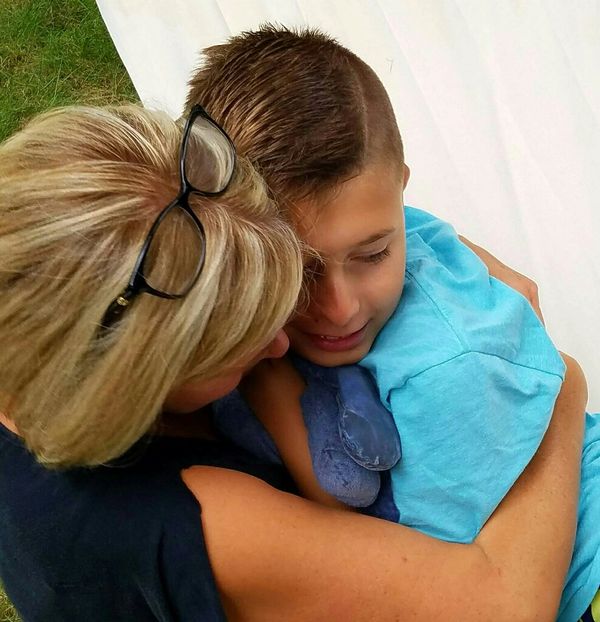 A tender hug between a woman and a boy, conveying warmth and affection.