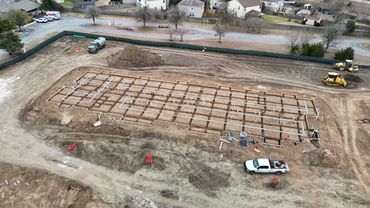 Construction site with foundation grid and machinery.