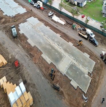 Aerial view of a construction site with concrete foundations and machinery.