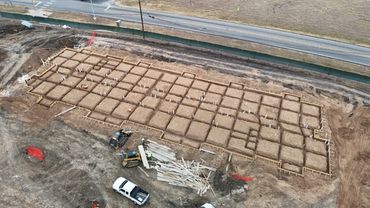Aerial view of a construction site with foundation trenches prepared for building.