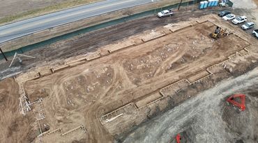 Aerial view of a construction site with groundwork and foundation layout.