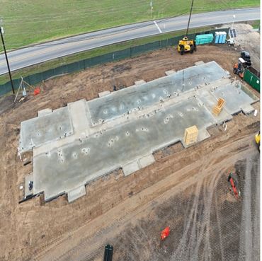 A concrete foundation slab for a building under construction at a roadside site.