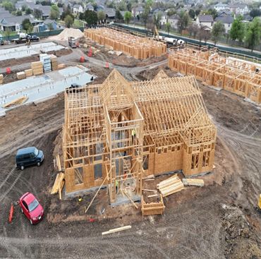 Wooden framework of houses under construction in a suburban area.