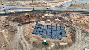 Construction site with foundation work and heavy machinery.