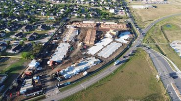 Aerial view of a housing construction site near a curved road.