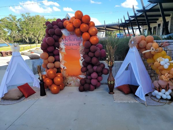 Outdoor party setup with balloons and teepees.