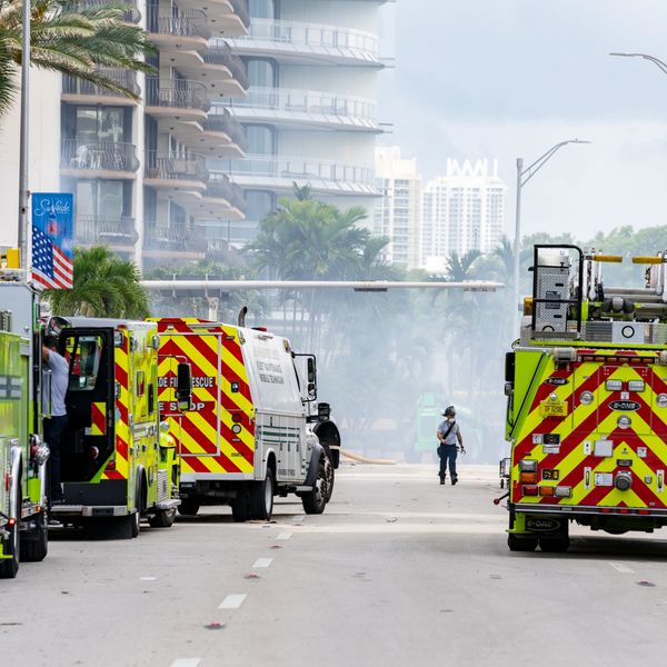 Fire trucks and emergency personnel on a city street responding to an incident.
