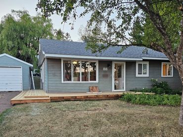 Single-story house with a wooden deck and a garage.