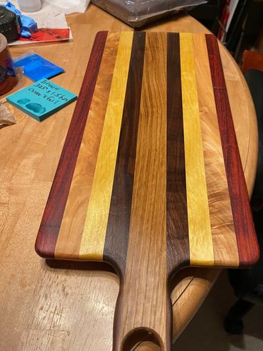 Board uses exotic & domestic hardwoods. Left 2 right Bloodwood, Maple, Yellowheart, Walnut, and Oak.