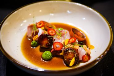 yellowtail crudo with bruleed cherry tomato chilis crunchy garlic and spicy ponzu sauce