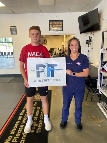 Young athlete and physical therapist holding a PIT Athlete's Choice sign.