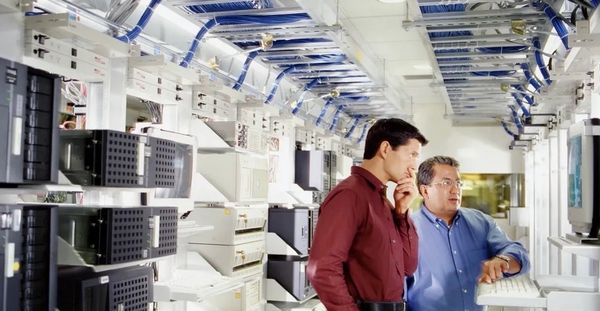 Two men examining servers in a data center.