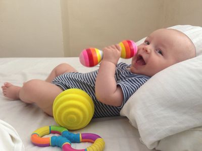 Contented baby playing with rattle
