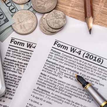 Tax Preparation, an Internal Revenue Service tax form with coins and both a pen and a pencil