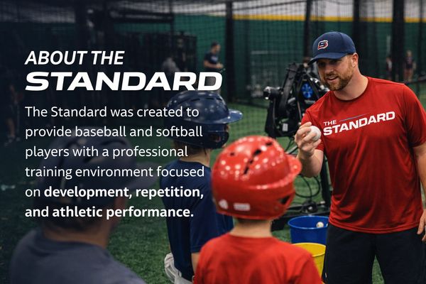 Coach instructs young baseball players at The Standard training facility.