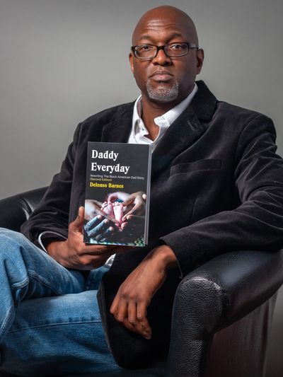 Delonso Barnes holding a book titled "Daddy Everyday."