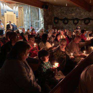 People holding candles during a candlelight service in a church.