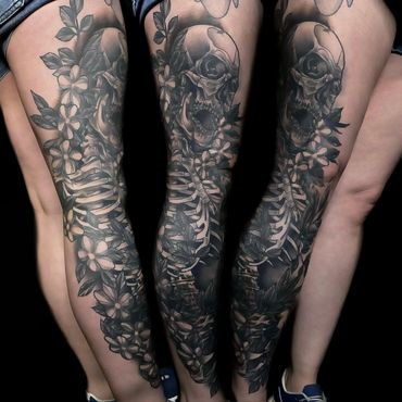 Three people with a skeleton and flowers tattoo on their legs