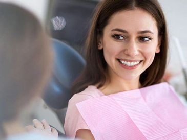 The patient consulting with the dentist, smiling.