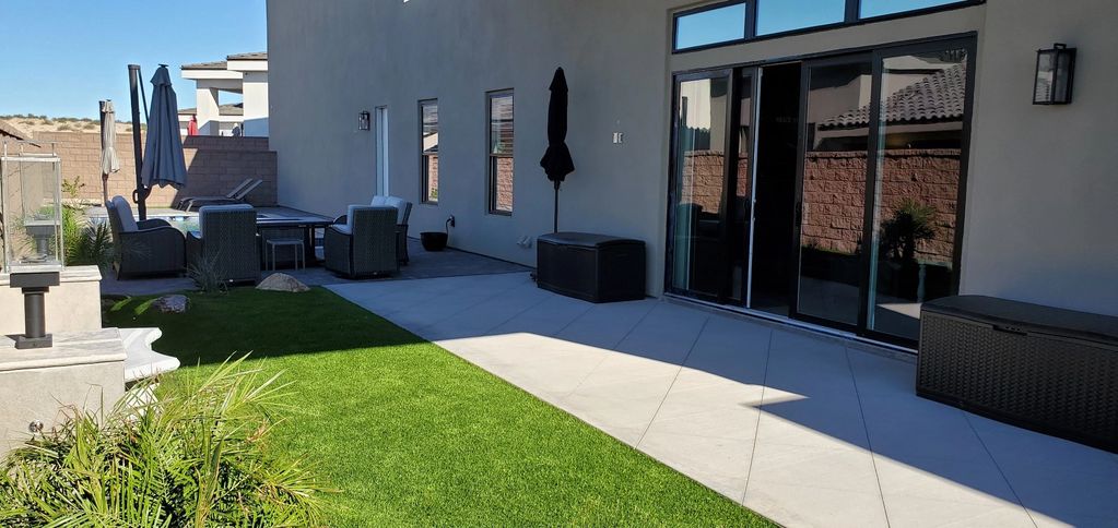 Modern backyard patio with lawn and seating area.