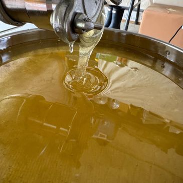 Golden honey flowing into a container.
