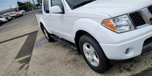 White pickup truck parked on wet pavement.