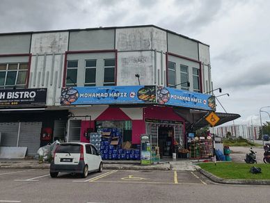 Corner shop named Mohamad Hafiz with various goods outside under a cloudy sky.