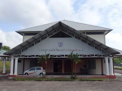 Exterior view of a building with a triangular roof and a parked car.