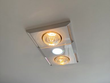 Ceiling light fixture with two warm bulbs and one bright white bulb.