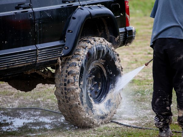 Off - road vehicle muddy tyre being washed