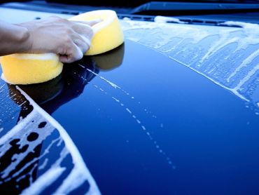 hand hold sponge over the car for washing