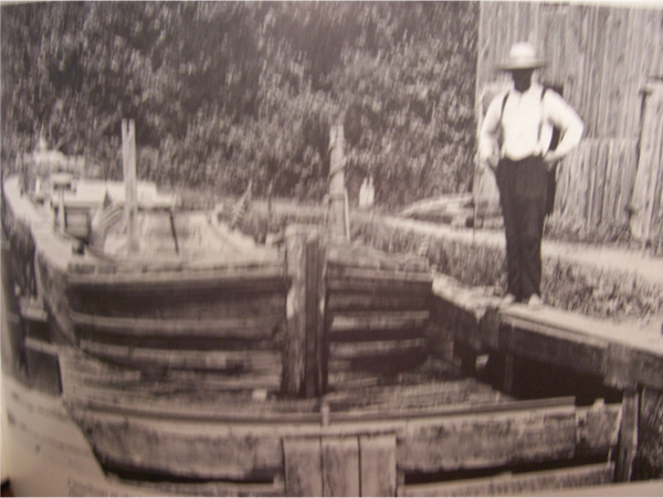 Black man standing beside a canal boat