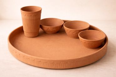 Terracotta serving set with a tray, cup, and three bowls, all featuring intricate patterns.